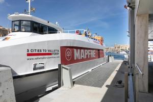 a large boat is docked at a dock at 3 Cities Harbour Townhouse - near Valletta Ferry in Cospicua