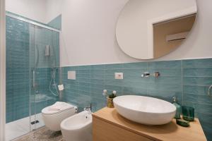 un bagno con lavandino, water e specchio di Mimi's Rooms - Charming Old Town a Bari Altre 31 foto