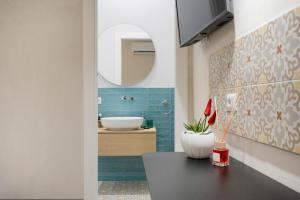 bagno con lavandino, specchio e tavolo di Mimi's Rooms - Charming Old Town a Bari