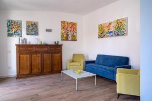 a living room with a blue couch and two chairs at Le Stagioni di Heraclea in Policoro