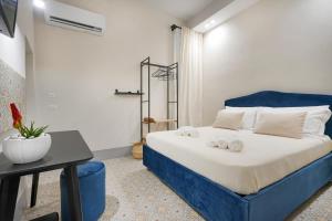 una camera da letto con un letto blu e asciugamani di Mimi's Rooms - Charming Old Town a Bari