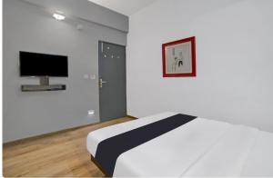 a bedroom with a bed and a flat screen tv at Olive Home Stay in Agra +3 photos