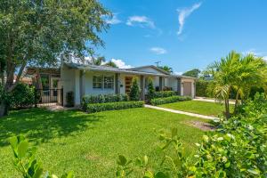 a house with a green yard at The Palm Grove in West Palm Beach