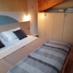 a small bedroom with a bed and a cabinet at Casa Osti in Spormaggiore