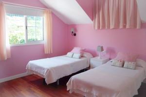 - une chambre rose avec 2 lits et une fenêtre dans l'établissement Holiday Home El Mar, à San Juan de la Rambla