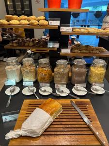 a table topped with jars of food and desserts at Hotel Saint Paul in Sao Jose do Rio Preto +138 photos