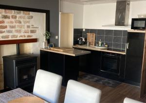 a kitchen with a stove and a sink and a counter at Entre terre et mer in Les Essarts