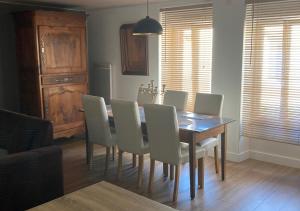 a dining room table with white chairs and a dining room at Entre terre et mer in Les Essarts +2 photos