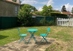 two blue chairs and a table in a yard at Entre terre et mer in Les Essarts