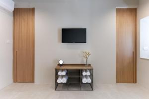 a room with a tv on a wall with a table at Historic Apartments - SUPER location near Valletta Ferry in Cospicua +89 photos