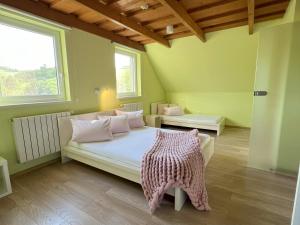 a bedroom with a bed and two windows at Drevenica Nela - Chalet in Tatras in Zuberec