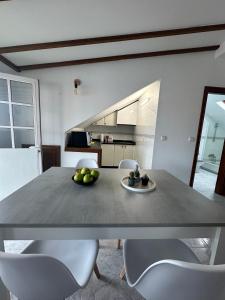 a kitchen with a table and chairs with fruit on it at Ático en el Centro de Cambados in Cambados