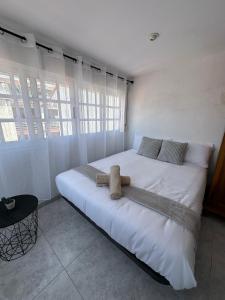 a large white bed in a room with windows at Ático en el Centro de Cambados in Cambados