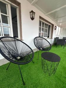 two chairs and a table on a yard with grass at Ático en el Centro de Cambados in Cambados