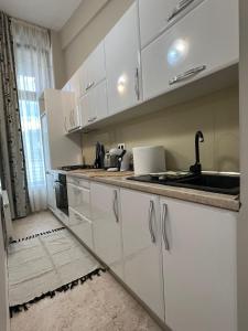 a kitchen with white cabinets and a sink at Apartment near IPJ IASI Copou in Iaşi