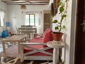 a living room with a couch and a table with a potted plant at Mumbi villa in Watamu