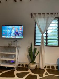 a living room with a flat screen tv and a window at Mumbi villa in Watamu
