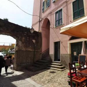 a building with stairs leading to a building with an arch at Ricky Rooms in Monterosso al Mare