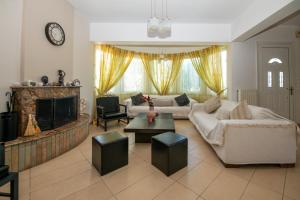 a living room with a couch and a fireplace at Olive Treasure Villa with Private Pool in Kolymbia