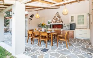 a kitchen and dining room with a wooden table and chairs at Olive Treasure Villa with Private Pool in Kolymbia