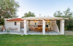a pergola with a table and chairs in a yard at Olive Treasure Villa with Private Pool in Kolymbia