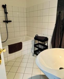 a white bathroom with a tub and a sink at Apartment Altstadtliebe in Bautzen +7 photos