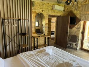 a bedroom with a bed and a mirror at Ekali stone house in Kaléntzion