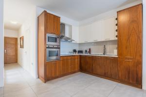 a large kitchen with wooden cabinets and appliances at Stunning 1-Bed Apartment In Heart of Valletta in Valletta