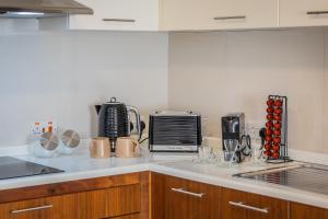 a kitchen with a counter top with a microwave and appliances at Stunning 1-Bed Apartment In Heart of Valletta in Valletta