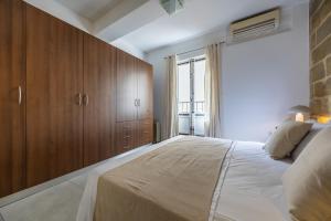 a bedroom with a large bed and wooden cabinets at Stunning 1-Bed Apartment In Heart of Valletta in Valletta