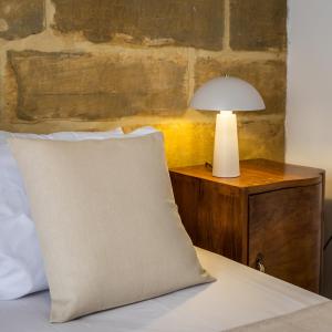 a bed with a pillow and a lamp on a nightstand at Stunning 1-Bed Apartment In Heart of Valletta in Valletta