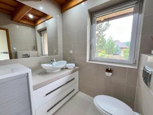 a bathroom with a sink and a toilet and a window at Drevenica Nela - Chalet in Tatras in Zuberec +44 photos