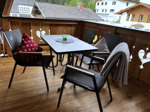 a patio table and chairs on a deck with a view at Ferienwohnungen Kirchenwirt in Thiersee +28 photos