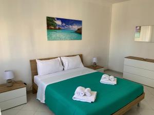 een slaapkamer met een bed met handdoeken erop bij Perla marina in Casa Santa