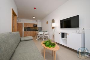 a living room with a couch and a table at Dąbki Beachfront Retreat in Dąbki