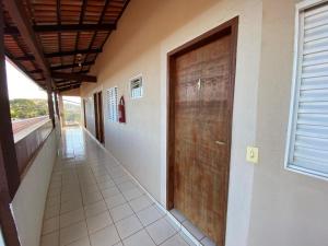 a hallway with a wooden door on the side of a building at Pousada Zoe in Pirenópolis +7 photos
