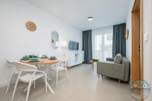 a dining room and living room with a table and chairs at Dąbki Beachfront Retreat in Dąbki