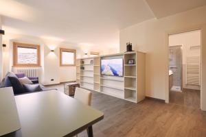 a living room with a couch and a tv at Le Corti Dei Sassi in Berbenno di Valtellina