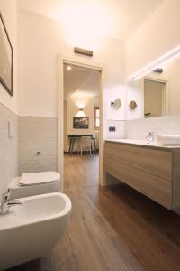 a bathroom with a sink and a toilet and a mirror at Le Corti Dei Sassi in Berbenno di Valtellina +41 photos