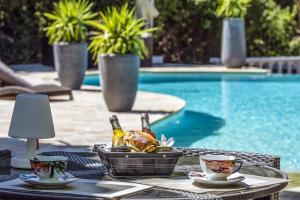 - une table avec un panier de nourriture et de boissons à côté de la piscine dans l'établissement B&B LES VOILES DE VALESCURE chambres d'hôtes et son espace bien être, à Saint-Raphaël