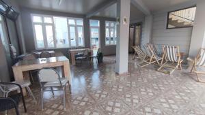 a room with chairs and a table and windows at Guest House ILIA 345 in Kobuleti