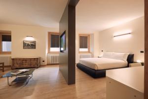a hotel room with a bed and a table at Le Corti Dei Sassi in Berbenno di Valtellina