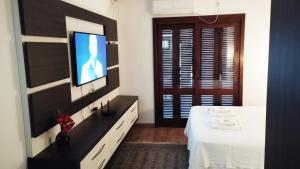 a bedroom with a television and a bed with a table at Recanto do Sossego-Suíte Master in Santa Cruz do Sul