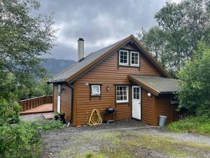 a small wooden house with a porch at Øen Hytter 1 in Sørbø