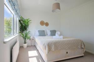 a bedroom with a bed with a stuffed animal on it at Hot Tub With A View - Christchurch Harbour in Christchurch