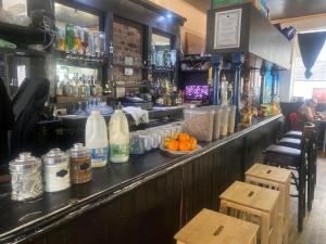 a bar with a counter with a lot of drinks at The Phoenix Hostel in London
