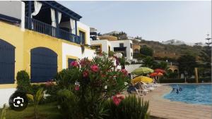a resort with a swimming pool and a building at Duplex B2 in Oualidia