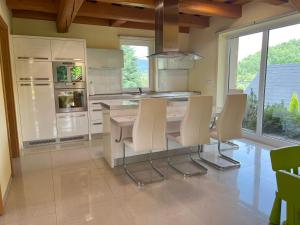 a kitchen with a table with chairs and a refrigerator at Drevenica Nela - Chalet in Tatras in Zuberec