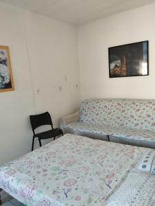 a small room with two beds and a chair at Suite Praias Penha SC in Penha