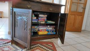 Una estantería de madera con libros dentro. en Freundliches Haus mit Pool und großem Garten, en Buis-les-Baronnies